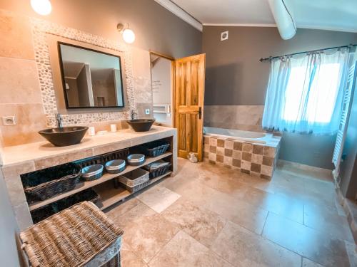 a bathroom with two sinks and a tub at Le Petit Rossignol in Apt