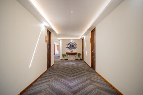 a corridor of a hallway with white walls and a table at Coral Reef Hotel & Spa, Port Blair in Port Blair