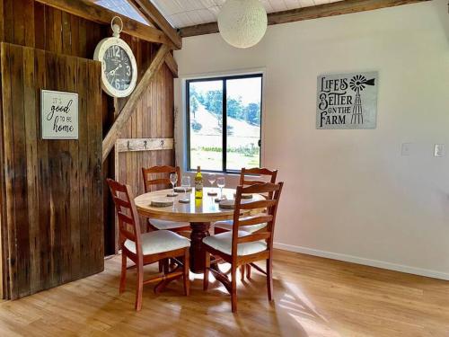 una sala da pranzo con tavolo, sedie e orologio di Stay at the Barn... Immerse yourself in nature. a Kenilworth