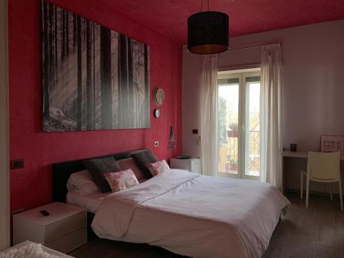 a bedroom with red walls and a bed with white sheets at Stileroma in Rome