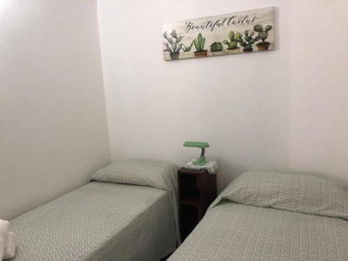 2 camas individuales en una habitación con una foto en la pared en casa salusa en Terrasini Favarotta
