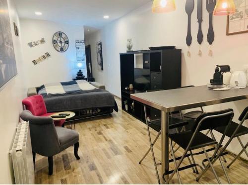 une chambre avec un lit, une table et des chaises dans l'établissement Bel appartement au cœur de paris, à Paris