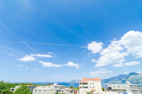 a kite flying in a blue sky with buildings at Guesthouse Somnium in Cavtat