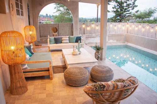 a living room with a pool and a table and chairs at Villa Ellena By The Villas 100 in Paragajen