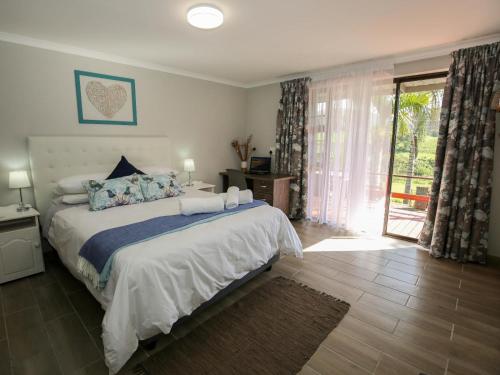 a bedroom with a large bed and a sliding glass door at Farm View Guest House in East London