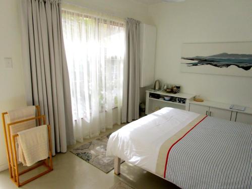 a bedroom with a bed and a large window at Sherwood Garden in Cape Town