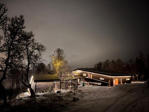 a house in the snow at night with at Håkøya Lodge in Tromsø