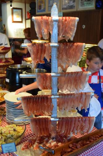 a tower of food on a table with plates of food at Hotel Villa Emilia in Ortisei