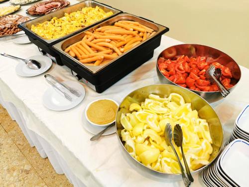 a table topped with bowls of food and vegetables at Hotel Montana - Covasna in Covasna