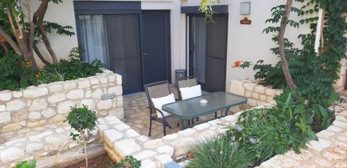 a patio with a table and chairs in front of a house at Artemis Village Apartments & Studios in Stavros