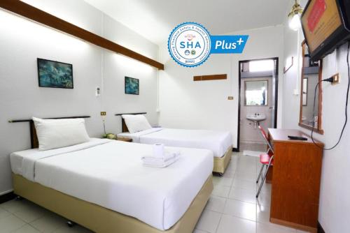 a hotel room with two beds and a sign that reads sing plus at Chomdoi House Hotel in Chiang Mai