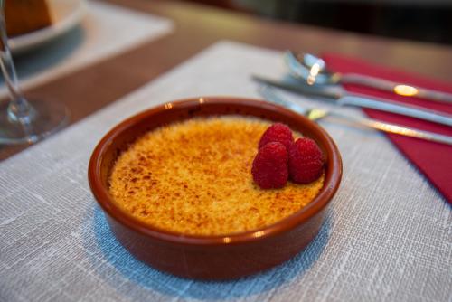 a bowl of food with raspberries on a table at Clarion Paris CDG Airport in Roissy-en-France