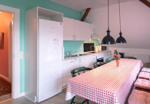 a kitchen and dining room with a table and chairs at Louiselund Bed & Breakfast in Haderslev