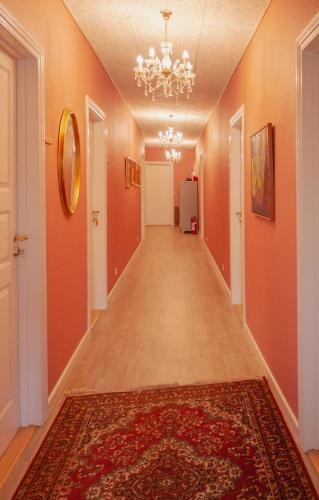 an empty hallway with orange walls and a rug at Louiselund Bed & Breakfast in Haderslev