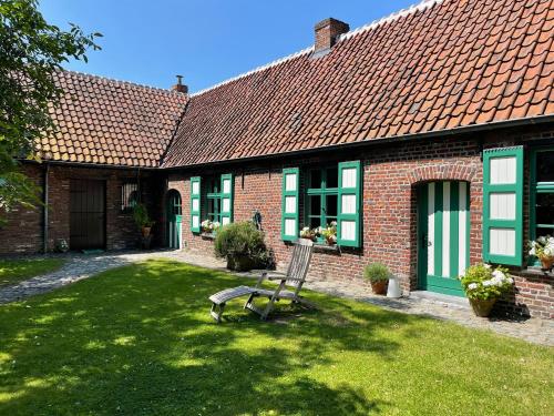 a brick house with a bench in the yard at Ma Campagne in Heusden