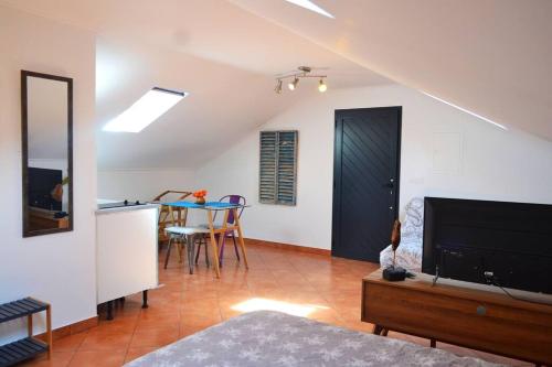 a living room with a television and a table with chairs at Lazy Lizard Studio in Seixal
