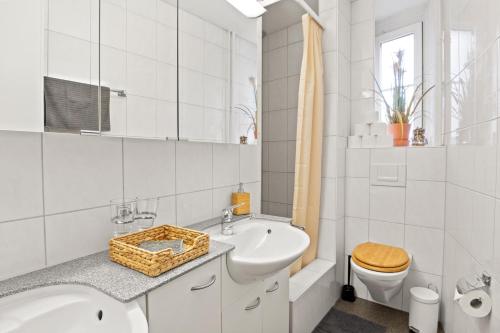 biała łazienka z wanną, umywalką i toaletą w obiekcie Modern & Central Apartments w Lucernie