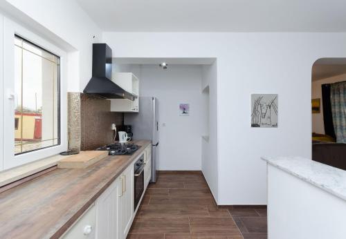 a kitchen with white walls and a large window at Apartments Milan in Rakalj