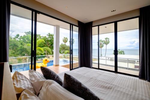 a bedroom with a large bed and large windows at Sunshine Paradise Resort in Ban Krut