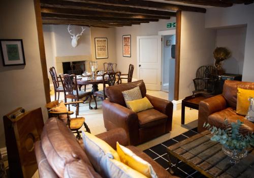 a living room with leather furniture and a dining room at The Candlemakers in Hexham