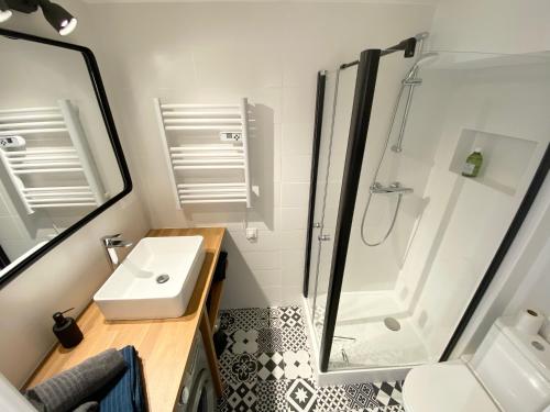 Un pequeño baño con lavabo y ducha. en L'OREE DE DEAUVILLE, CHARMANT DUPLEX PROCHE PLAGE, en Tourgéville