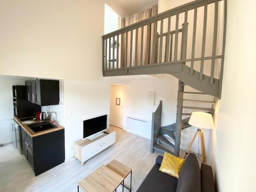 a living room with a couch and a staircase at L'OREE DE DEAUVILLE, CHARMANT DUPLEX PROCHE PLAGE in Tourgeville