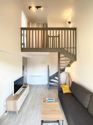 un salon avec un canapé et un escalier dans l'établissement L'OREE DE DEAUVILLE, CHARMANT DUPLEX PROCHE PLAGE, à Tourgéville
