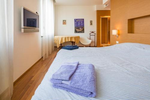 a bedroom with a large bed with two towels on it at Arena Verona Centro in Verona