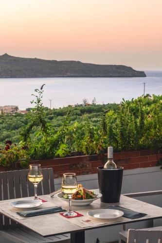 a table with two glasses of wine and a plate of food at Chrissida Hotel in Nea Kydonia