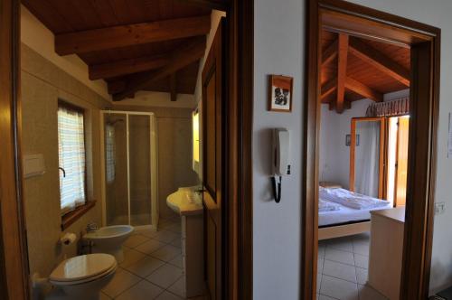 La salle de bains est pourvue de toilettes et d'un lavabo. dans l'établissement Residence Mirabel, à Tignale