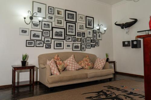 a living room with a couch and a wall of pictures at Tshukudu Game Lodge in Hoedspruit