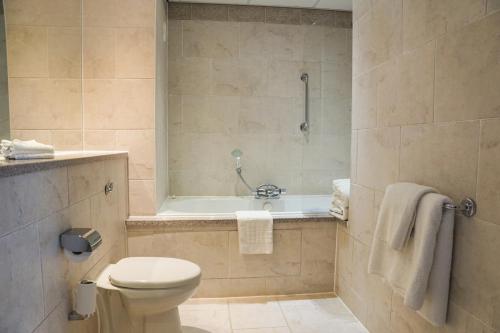 a bathroom with a toilet and a bath tub at Crowne Plaza Liverpool City Centre, an IHG Hotel in Liverpool