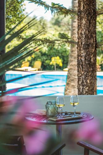 two wine glasses sitting on a table next to a pool at Chrissida Hotel in Nea Kydonia