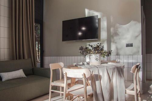 a dining room with a table and chairs and a tv at Domki MODERN Jezioro Nyskie in Nysa
