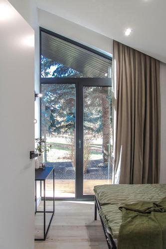 a bedroom with a bed and a large sliding glass door at Domki MODERN Jezioro Nyskie in Nysa
