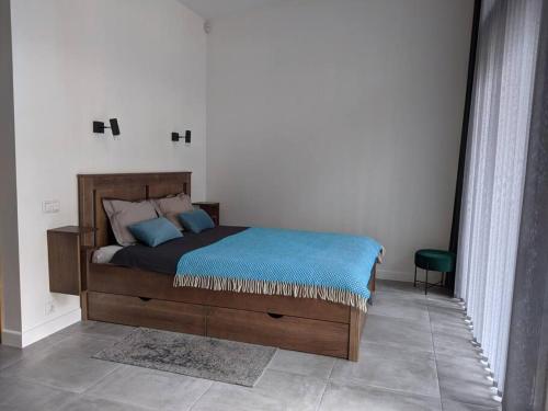 a bedroom with a bed with a blue blanket on it at GaujaUpe in Gauja