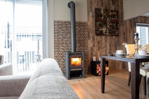 a living room with a couch and a fireplace at Welgedacht in Sint Annaland