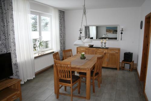 uma sala de jantar com uma mesa de madeira e cadeiras em Ferienhaus Frey em Eggebek