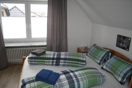 a bedroom with two twin beds and a window at Frey - Ferienhaus über zwei Etagen mit Terrasse in Eggebek