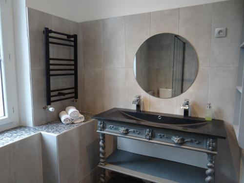 une salle de bain avec un lavabo noir et un miroir dans l'établissement Au bon coin, à Sarlat-la-Canéda