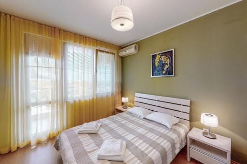 una camera da letto con un letto e una grande finestra di Apartments at Lighthouse Golf by Parnas Estate a Balchik