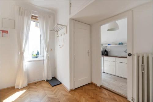una cucina con pareti bianche e pavimenti in legno massello di City Center Operastreet Apartment "Italy" a Vienna