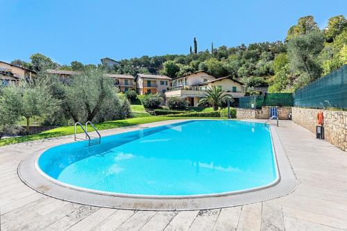 - une grande piscine dans une cour avec des maisons dans l'établissement Al Vittoriale 3 by Wonderful Italy, à Gardone Riviera