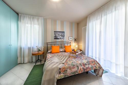 Un dormitorio con una cama con almohadas naranjas. en Al Vittoriale 3 by Wonderful Italy, en Gardone Riviera