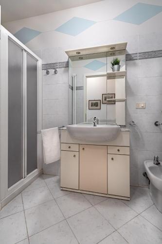 a bathroom with a sink and a shower and a mirror at Al Vittoriale 3 by Wonderful Italy in Gardone Riviera