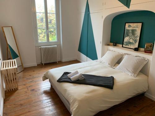 - une chambre avec un grand lit blanc et une tête de lit verte dans l'établissement Au bon coin, à Sarlat-la-Canéda