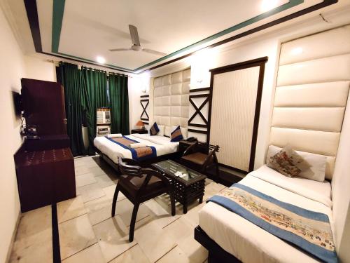 a hotel room with two beds and a table at Hotel Unistar in New Delhi