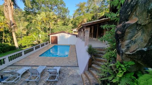 a backyard with a swimming pool and a house at Espaço Casa na Rocha in São José dos Campos