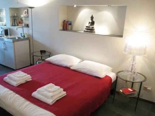 a bedroom with a red bed with towels on it at Amsterdam Canal Guest Apartment in Amsterdam