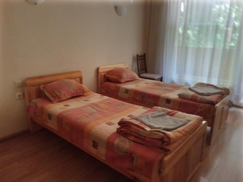 a bedroom with three beds and a window at Семеен хотел Чекръка in Iskŭr